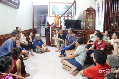 Thuyền viên Đinh Trọng Dũng, 57 tuổi (áo xanh ngồi trên giường) chia sẻ với gia đình và người thân. (Ảnh: Nguyễn Oanh/TTXVN)