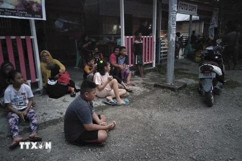 Người dân chạy ra khỏi nhà do lo ngại những dư chấn sau trận động đất mạnh 7,3 độ tại Labuha, Indonesia, ngày 14/7. (Ảnh: AFP/TTXVN)