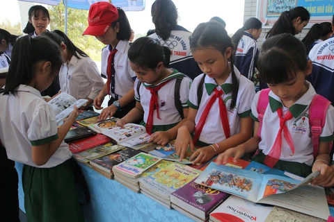 Học sinh huyện Quảng Điền tham quan triển lãm và đọc sách trong Ngày sách Việt Nam. (Ảnh: Hồ Cầu/TTXVN)