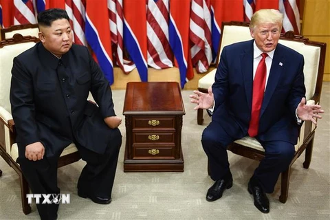 Tổng thống Mỹ Donald Trump (phải) và nhà lãnh đạo Triều Tiên Kim Jong-un trong cuộc gặp ở làng đình chiến Panmunjom tại Khu phi quân sự (DMZ) chiều 30/6/2019. (Ảnh: AFP/TTXVN)