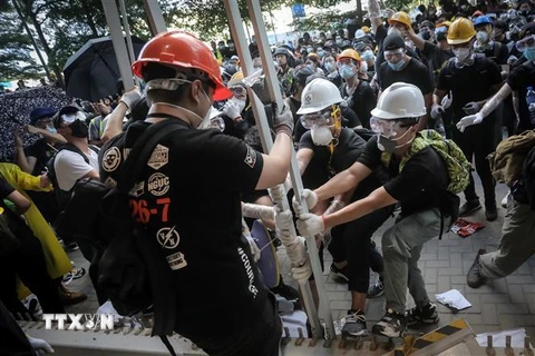 Những người biểu tình quá khích phá hàng rào để tràn vào tòa nhà cơ quan lập pháp ở Hong Kong, Trung Quốc, ngày 1/7. (Ảnh: AFP/TTXVN)