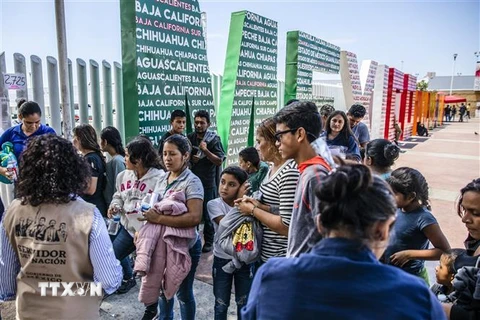 Người di cư bị trục xuất khỏi Mỹ tập trung tại khu vực biên giới Mỹ-Mexico, trước khi được đưa về một trại tạm ở Tijuana, Mexico ngày 22/7/2019. (Ảnh: AFP/TTXVN)