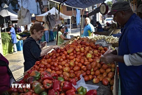 Người dân mua bán hàng hóa tại chợ ở Caracas, Venezuela, ngày 28/3/2019. (Ảnh: AFP/ TTXVN)