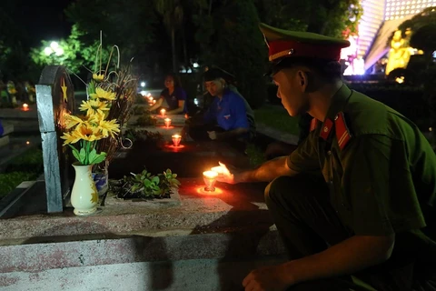 Các đoàn viên thanh niên thắp nến tri ân các anh hùng liệt sỹ tại Điện Biên. (Ảnh: Phan Tuấn Anh/TTXVN)