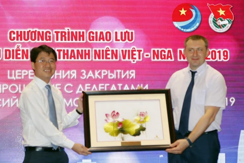 Đại diện Thành Đoàn Thanh niên Cộng sản Hồ Chí Minh tặng quà lưu niệm cho ông Alexander Bugaev (Ảnh: Hoàng Hải/TTXVN)