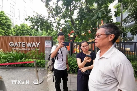 Phóng viên phỏng vấn người dân tại cổng trường Quốc tế Gateway. (Ảnh: Thành Đạt/ TTXVN)