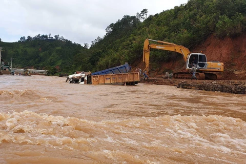 Nhiều xe tải, máy móc của một trang trại sản xuất nông nghiệp tại huyện Lạc Dương bị nước lũ cuốn xuống suối. (Ảnh: Nguyễn Dũng/TTXVN)