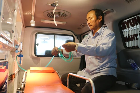 Ông Ngô Văn Đậu đang kiểm tra lại các thiết bị hỗ trợ cấp cứu trên xe chuyển viện do ông và gia đình mua trị giá 700 triệu đồng để vận chuyển bệnh nhân miễn phí. (Ảnh: Công Mạo/TTXVN)