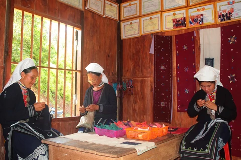 Những lúc nông nhàn phụ nữ Dao Tiền ở Nà Chắn (xã Hoa Thám, huyện Nguyên Bình) thường tập trung tại xưởng dệt để thêu thổ cẩm. (Ảnh: Chu Hiệu/TTXVN)
