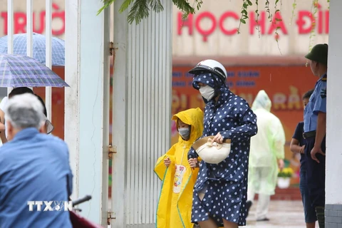 Các bậc phụ huynh đón con nhỏ luôn đeo khẩu trang tại Trường Tiểu học Hạ Đình, cách hiện trường vụ cháy Nhà xưởng Công ty Rạng Đông chưa đến 1km. (Ảnh: Thành Đạt/TTXVN)