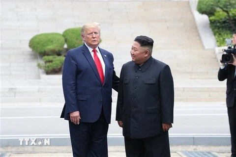 Tổng thống Mỹ Donald Trump (trái) và nhà lãnh đạo Triều Tiên Kim Jong-un trong cuộc gặp ở làng đình chiến Panmunjom tại Khu phi quân sự (DMZ) chiều 30/6/2019. (Ảnh: Yonhap/TTXVN)