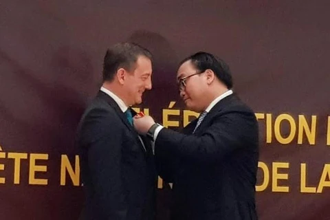Bí thư Thành ủy Hà Nội Hoàng Trung Hải (bên phải) trao Huân chương Hữu nghị của Chủ tịch nước tặng Đại sứ Pháp tại Việt Nam Bertrand Lortholary. (Ảnh: Linh Hương/TTXVN)