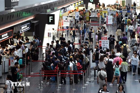 Hành khách tại sân bay Haneda ở thủ đô Tokyo, Nhật Bản. (Ảnh: AFP/ TTXVN)