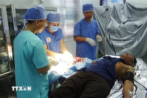 Các y, bác sỹ xã đảo Song Tử Tây đang phẫu thuật cho bệnh nhân Phạm Văn Khương. (Ảnh: TTXVN phát)