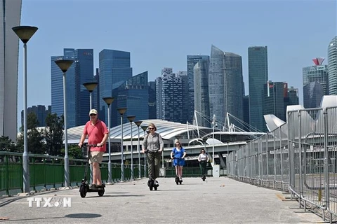 Khách du lịch lái e-scooter tại Singapore ngày 19/2/2019. (Ảnh: AFP/TTXVN)
