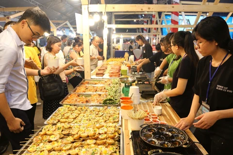 Đông đảo thực khách trong nước và quốc tế thưởng thức món bánh khọt tại liên hoan. (Ảnh: Thanh Vũ/TTXVN)