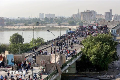 Người biểu tình phản đối chính phủ Iraq tràn vào cây cầu al-Sinek để tiến vào vùng Xanh ở thủ đô Baghdad ngày 17/11/2019. (Ảnh: AFP/TTXVN)