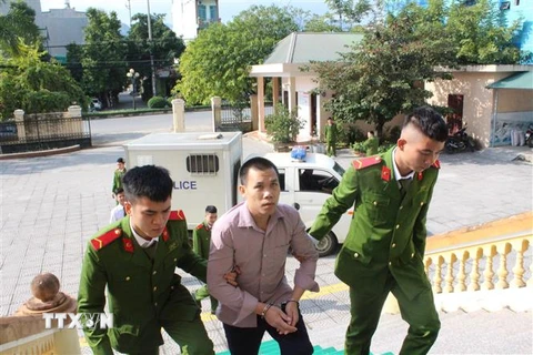 Bị cáo Bùi Văn Thuấn được lực lượng chức năng dẫn giải vào phòng xét xử. (Ảnh: Vũ Hà/TTXVN)