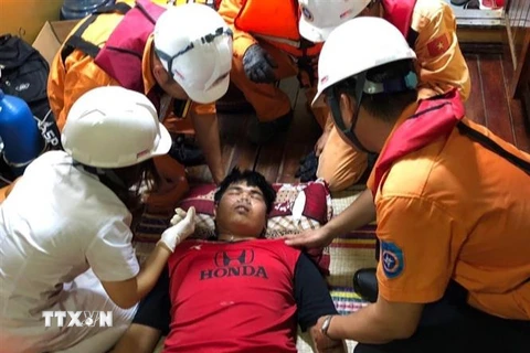 Lực lượng cứu nạn tiếp cận thủy thủ Thái Lan đang gặp vấn đề sức khỏe. (Ảnh: TTXVN phát)