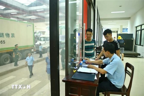Nhân viên Chi cục Hải quan cửa khẩu quốc tế Cha Lo làm thủ tục cho người và phương tiện qua cửa khẩu. (Ảnh: Minh Quyết/TTXVN)