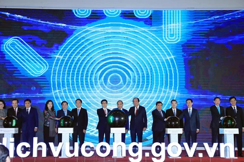 Thủ tướng Nguyễn Xuân Phúc và các đại biểu thực hiện nghi thức khai trương Cổng Dịch vụ công Quốc gia. (Ảnh: Thống Nhất/TTXVN)