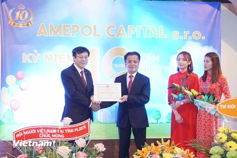 Đại sứ Hồ Minh Tuấn trao giấy khen cho Công ty Amepol Capital. (Ảnh: Hồng Kỳ/Vietnam+)