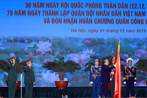 Thủ tướng Nguyễn Xuân Phúc, Chủ tịch Hội đồng thi đua - khen thưởng Trung ương trao tặng Huân chương Quân công hạng Nhất cho Bộ Quốc phòng. (Ảnh: Thống Nhất/TTXVN)