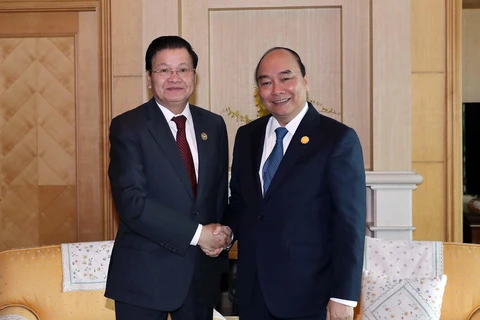 Thủ tướng Nguyễn Xuân Phúc gặp Thủ tướng Lào Thongloun Sisoulith tại Busan, Hàn Quốc. (Ảnh: Thống Nhất/TTXVN)
