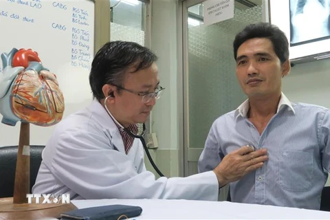 Tiến sỹ, bác sỹ Nguyễn Thái An, Trưởng Khoa Hồi sức phẫu thuật tim - Bệnh viện Chợ Rẫy tái khám cho bệnh nhân sau khi áp dung phương pháp phẫu thuật tim mới. (Ảnh: Đinh Hằng/TTXVN)