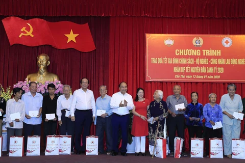 Thủ tướng Nguyễn Xuân Phúc tặng quà gia đình chính sách, hộ nghèo tại thành phố Cần Thơ. (Ảnh: Thống Nhất/TTXVN)