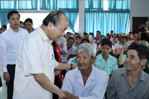 Thủ tướng Nguyễn Xuân Phúc thăm hỏi, động viên các đối tượng chính sách tỉnh Vĩnh Long. (Ảnh: Thống Nhất/TTXVN)
