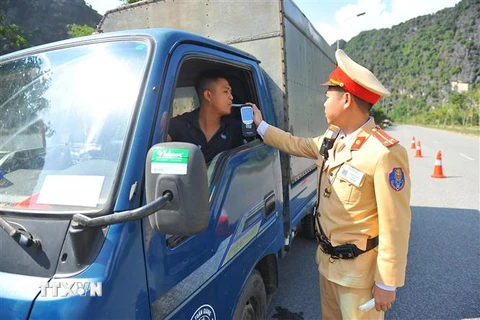 Cảnh sát giao thông huyện Hoa Lư, Ninh Bình kiểm tra nồng độ cồn của lái xe. (Ảnh: Minh Đức/TTXVN)