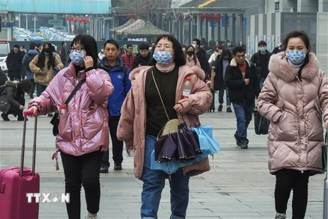 Hành khách đeo khẩu trang khi di chuyển tại một nhà ga ở Hồ Bắc, Trung Quốc để phòng tránh lây nhiễm dịch bệnh viêm phổi do virus corona ngày 21/1/2020. (Ảnh: AFP/TTXVN)