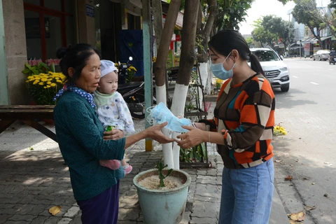 Chủ cửa hàng Bống Tea and Coffe (136C Ông Ích Đường, thành phố Đà Nẵng) phát khẩu trang miễn phí cho khách hàng. (Ảnh: Văn Dũng/ TTXVN)