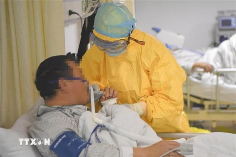 Nhân viên y tế hỗ trợ bệnh nhân nhiễm virus COVID-19 tại bệnh viện ở thành phố Trùng Khánh, Trung Quốc ngày 1/2/2020. (Ảnh: THX/TTXVN)