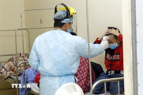 Nhân viên y tế kiểm tra thân nhiệt cho các ca bệnh đang được cách ly theo dõi nCoV tại Trung tâm Y tế Bình Xuyện (ảnh chụp chiều 7/2). (Ảnh: Dương Ngọc/TTXVN)