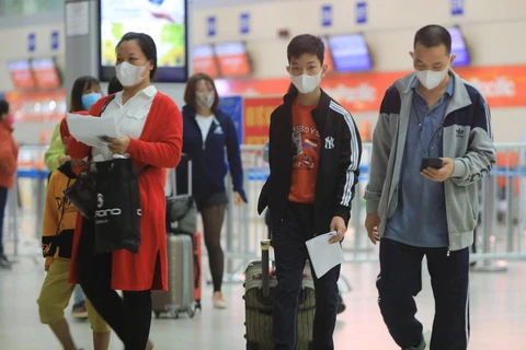 Hành khách sử dụng khẩu trang phòng chống dịch bệnh khi tham gia các phương tiện công cộng tại sân bay quốc tế Nội Bài (ảnh chụp sáng 14/2/2020). (Ảnh: Nhật Anh/TTXVN)