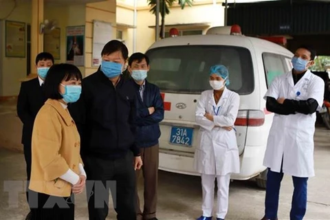 Đoàn công tác kiểm tra công tác phòng chống dịch COVID-19 tại Trạm y tế xã Sơn Lôi. (Ảnh: Hoàng Hùng/TTXVN)
