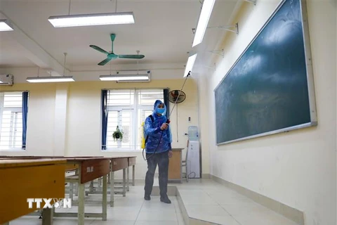 Phun thuốc khử trùng lần thứ 6 tại trường THPT Trần Nhân Tông, Hà Nội. (Ảnh: Thanh Tùng/TTXVN)