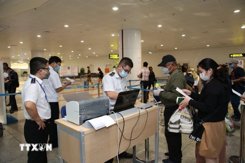 Hành khách làm thủ tục khai báo y tế trước khi nhập cảnh vào Việt Nam tại cửa khẩu Sân bay quốc tế Nội Bài (Hà Nội), chiều 7/3. (Ảnh minh họa: Dương Giang/TTXVN)