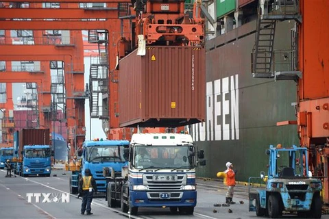 Bốc dỡ hàng hóa tại cảng ở Tokyo, Nhật Bản. (Ảnh: AFP/ TTXVN)