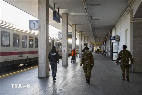 Cảnh sát và binh sỹ Italy tuần tra tại nhà ga đường sắt ở Rimini trong bối cảnh quốc gia này áp dụng lệnh phong tỏa trên toàn quốc nhằm ngăn chặn dịch COVID-19, ngày 8/3/2020. (Ảnh: AFP/TTXVN)