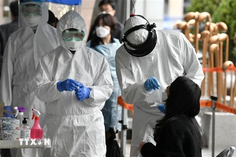 Nhân viên y tế Hàn Quốc lấy mẫu bệnh phẩm của các nhân viên bị nghi nhiễm COVID-19 tại một tòa nhà ở Seoul, nơi phát hiện 46 ca dương tính với virus SARS-CoV-2, ngày 10/3/2020. (Ảnh: AFP/TTXVN)