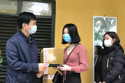 Đại diện Trung tâm Kiểm soát bệnh tật tỉnh Thanh Hóa trao giấy chứng nhận cho 166 công dân. (Ảnh: Hoa Mai/TTXVN)