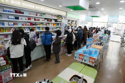 Người dân xếp hàng chờ mua khẩu trang tại một hiệu thuốc ở Gwangju, cách thủ đô Seoul của Hàn Quốc 329km về phía nam, ngày 15/3/2020. (Ảnh: Yonhap/ TTXVN)