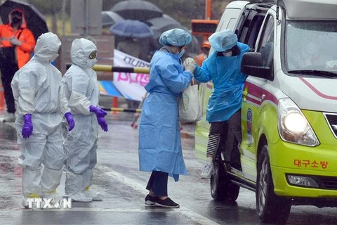 Nhân viên y tế hỗ trợ bệnh nhân nhiễm COVID-19 tại một bệnh viện ở Daegu, Hàn Quốc ngày 7/3/2020. (Ảnh: THX/TTXVN)