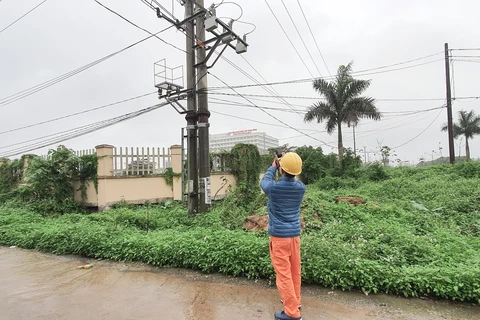 Công nhân Công ty Điện lực Đông anh kiểm tra đo nhiệt tại mối tiếp xúc cấp điện cho Bệnh viện Nhiệt đới Trung ương cơ sở Đông Anh. (Ảnh: Mạnh Khánh/TTXVN)