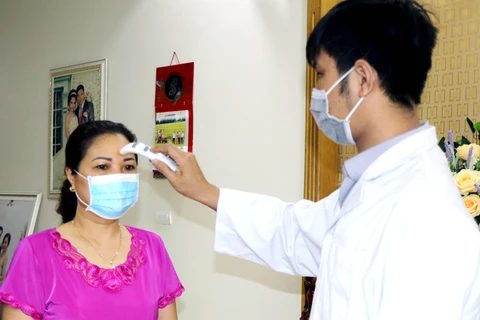 Nhân viên tế Trạm y tế phường Hồng Hà khám sức khỏe tại gia đình số nhà 18, đường Đặng Thùy Châm, thành phố Hạ Long. (Ảnh: Văn Đức/TTXVN)