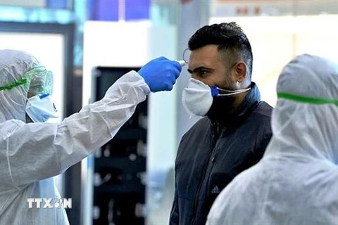 Nhân viên y tế kiểm tra thân nhiệt của người dân trong bối cảnh dịch COVID-19 lan rộng tại Tehran, Iran. (Ảnh: IRNA/ TTXVN)
