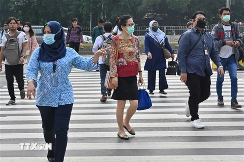 Người dân đeo khẩu trang phòng lây nhiễm COVID-19 tại Jakarta, Indonesia, ngày 19/3/2020. (Ảnh: AFP/TTXVN)